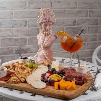 Chracuterie board accompanied with a cocktail drink.