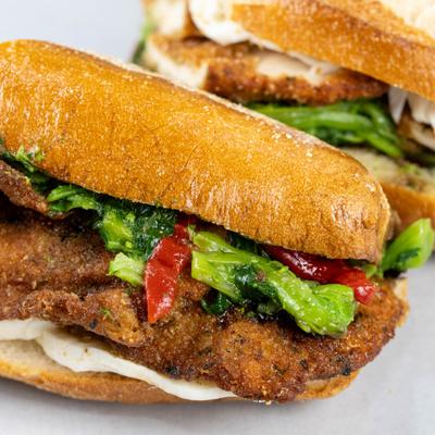 Chicken cutlet hero sandwich with mozzarella, broccoli rabe, and roasted peppers.