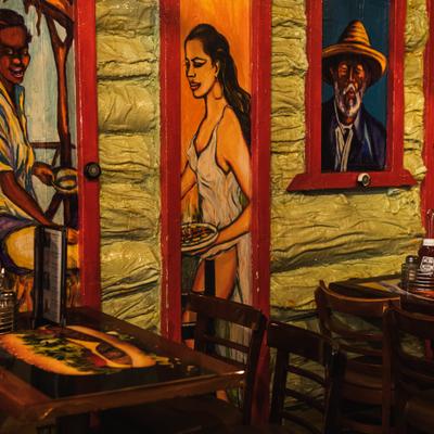 Interior of a restaurant featuring distinct murals and Dominican-style decor.
