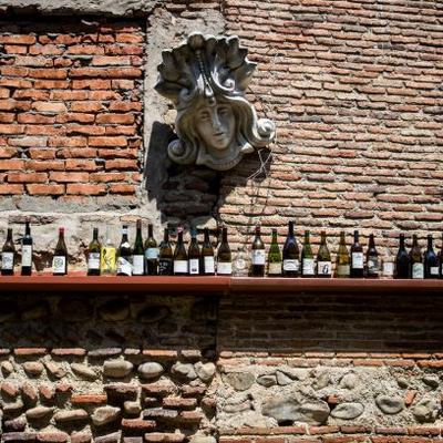 shelf of wine bottles under bust