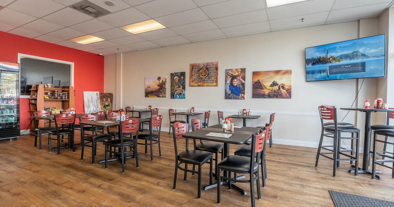 Interior, large TV in the corner, tables with chairs
