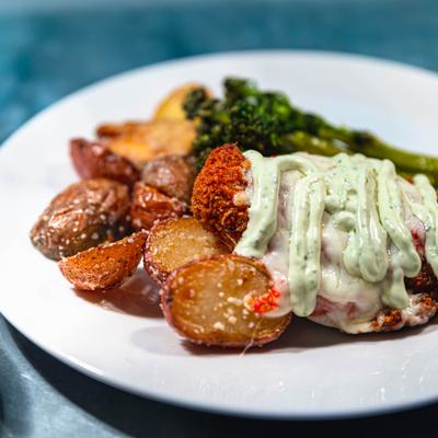 Chicken Parmesan, served with roasted potatoes and broccolini