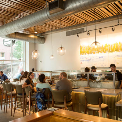 View of oyster bar with customers and chefs preparing dishes