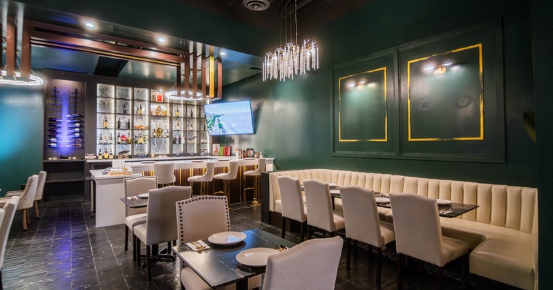 A modern elegant restaurant interior with a bar, cushioned seating, and elegant lighting