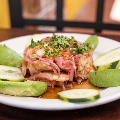 Cooked shrimp, with cabbage relish, lime juice, avocado, onion, cucumber, and peppers.