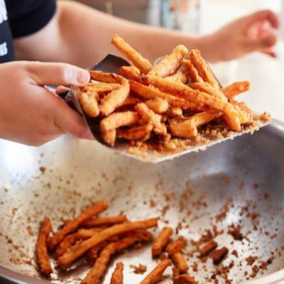French fries being scooped from a large container.