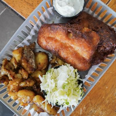 Fish and chips, accompanied by slaw and tartare sauce.