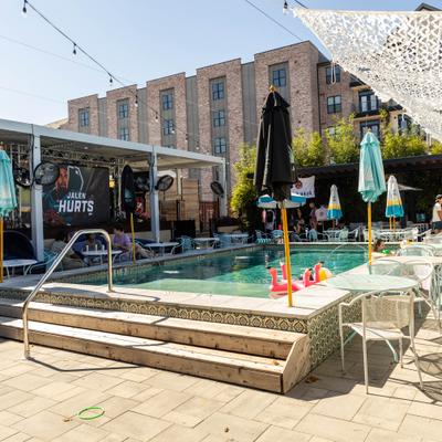 Outdoor pool area with lounge chairs and umbrellas.