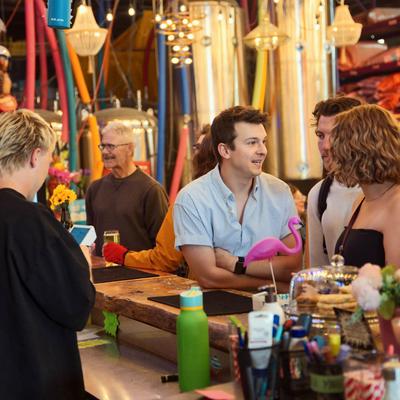 Friends socializing at a colorful bar counter.