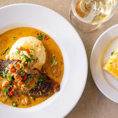Chicken fillet in tomato sauce, served over rice, with jalapeno cornbread and white wine