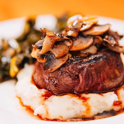 Filet Mignon atop mashed potatoes with with mushroom demi-glace.
