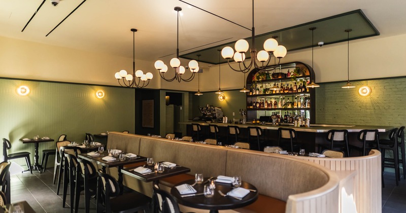 Interior, dining area, long banquette bench with tables and chairs, ready for guests