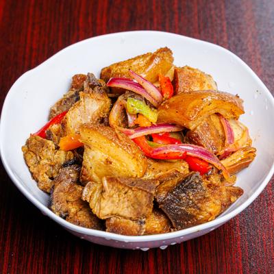 Fried pork pieces with onions and peppers.