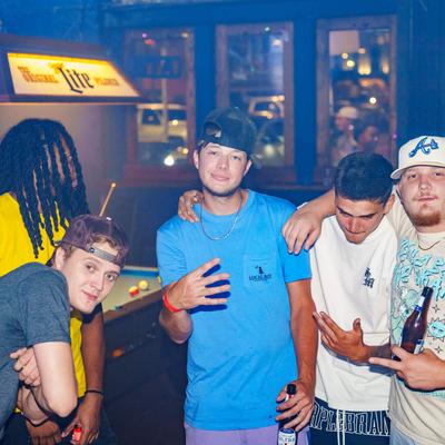 Guests posing for a photo showing gang signs with hands.