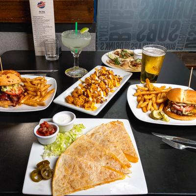 A table with assorted food plates and drinks on it.
