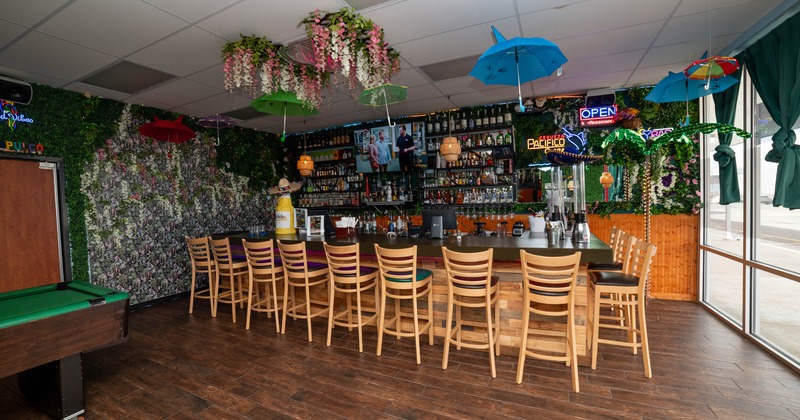 Cozy bar with wooden chairs lined up along a counter