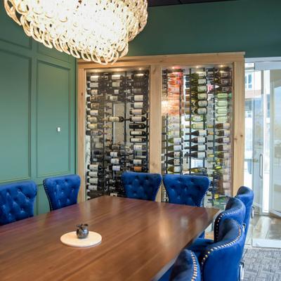 Interior, seating area with blue chairs and shelf with wines