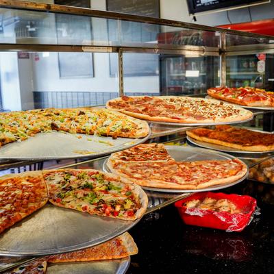 Display case with assorted pizzas.
