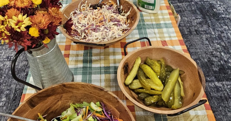 A table set with bowls of salad and a flower arrangement