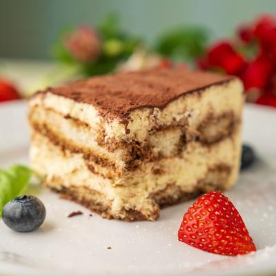 Tiramisu layered on a plate with fresh berries.