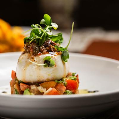 Caprese salad with burrata, tomatoes, avocado, and olive tapenade.
