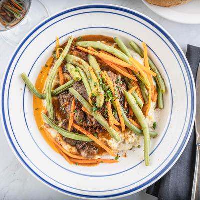 Braised Beef Short Rib, on a bed of mashed potatoes, with carrots, and green beans.