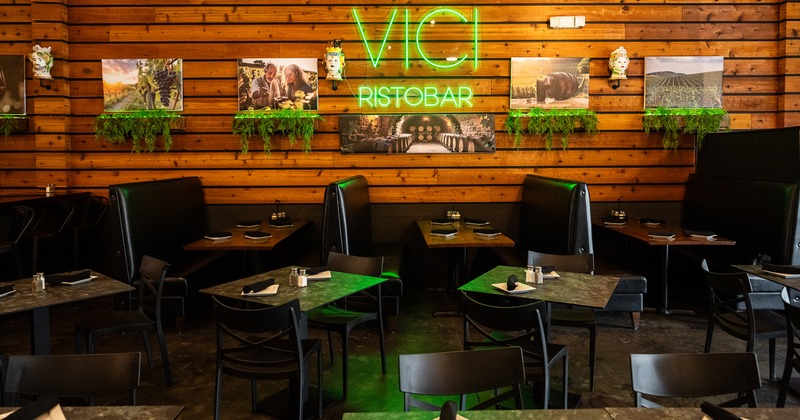 Interior dining area with set dining tables and upholstered booths along the wall