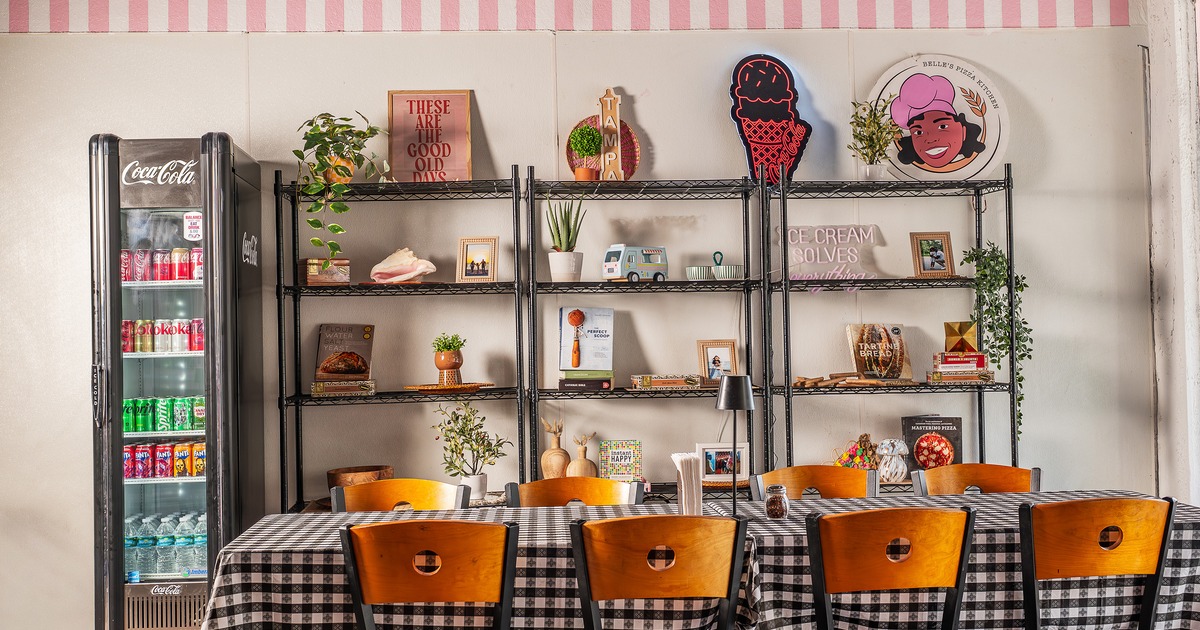 Dining table for eight guests with black-and-white checkered tablecloth and wooden chairs
