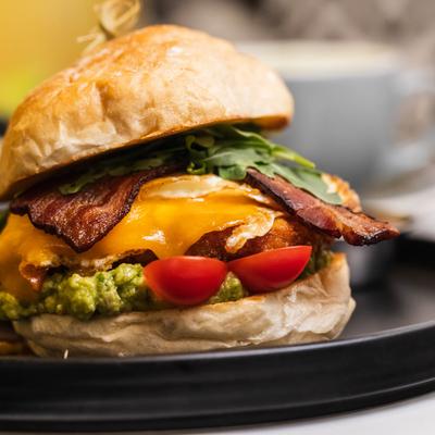 Bacon cheeseburger with arugula and cherry tomatoes.