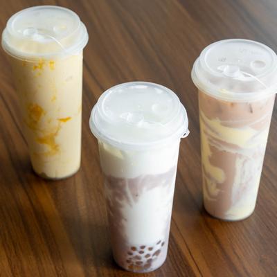 Three bubble tea drinks in tall plastic cups.