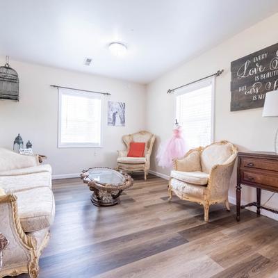 Bright room with vintage furniture, an empty birdcage, and wall art.