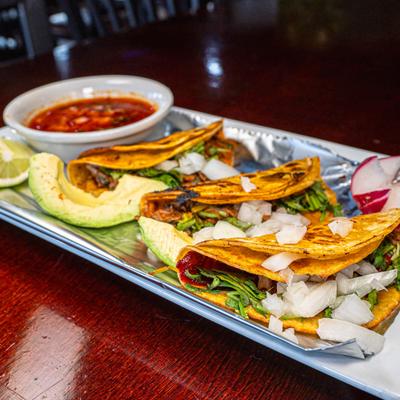 Crispy beef birria tacos served with warm savory dipping consommé.