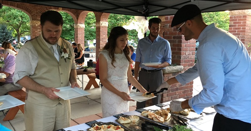 An employee serving food to people at a wedding
