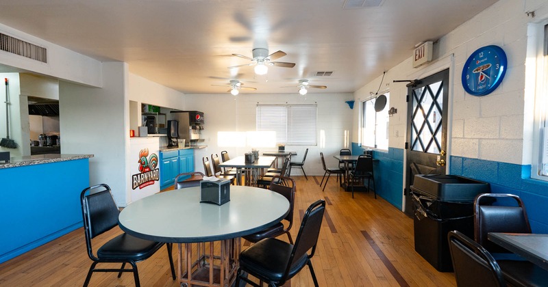Dining room with wooden floors, blue and white walls, black tables and chairs