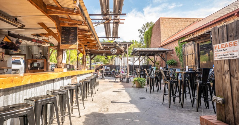 Exterior, seating area, with a bar, high tables and chairs