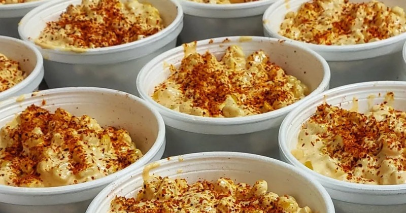 Several servings of elote in individual white containers