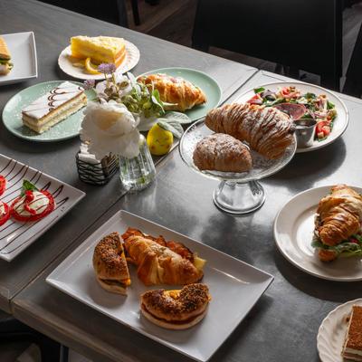 Assorted pastries, sandwiches, and desserts arranged on a table.
