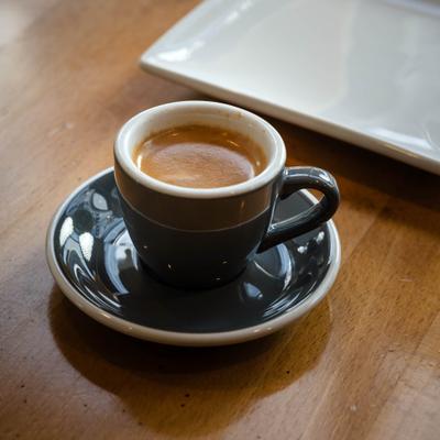 Espresso coffee served in a small cup on a saucer.