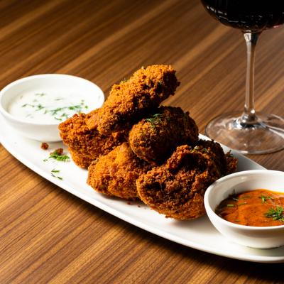 Mediterranean Chicken Wings served with two dipping sauces and a glass of wine.