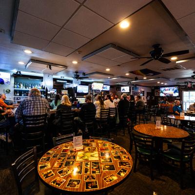 Dining area's interior with a view at people seating at the bar.