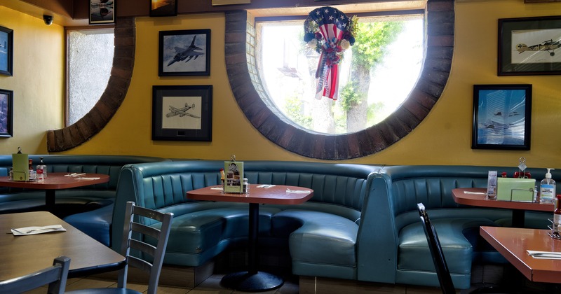 Interior dining area with half round upholstered dining booths ready for guests