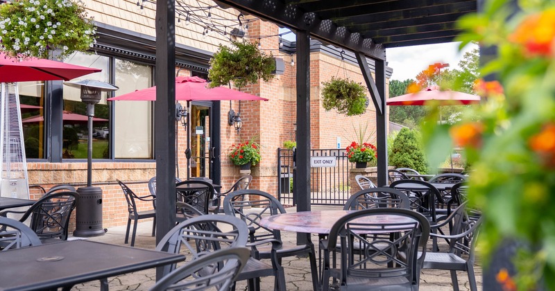 Outdoor restaurant patio with tables, chairs and red umbrellas