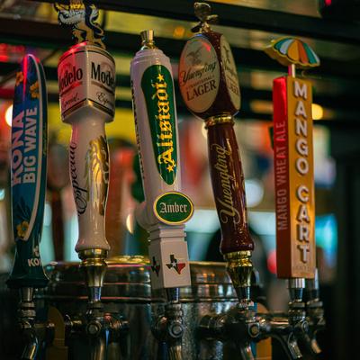Assorted beer taps with colorful labels.