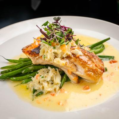 Redfish Anna with Lump Crab Meat served in a sauce with green beans.