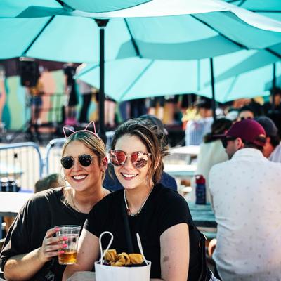 Two girls drinking a beer.