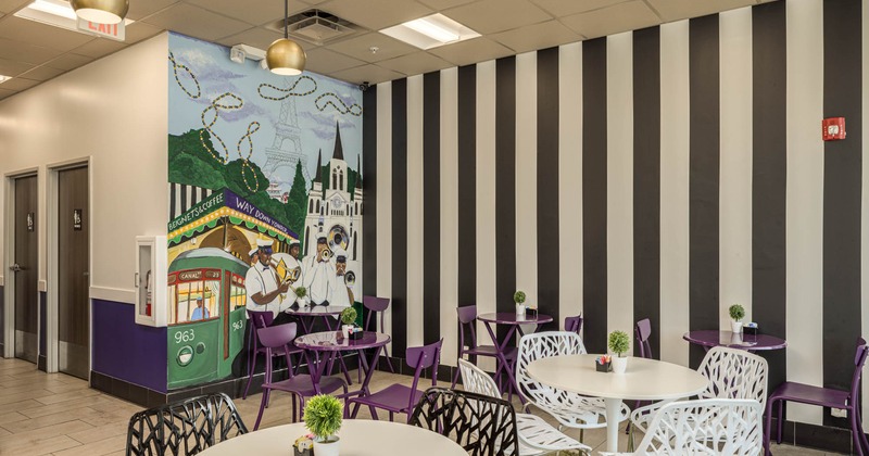 Interior, seating area, mural on the wall on the left, vertical stripe pattern on the right wall