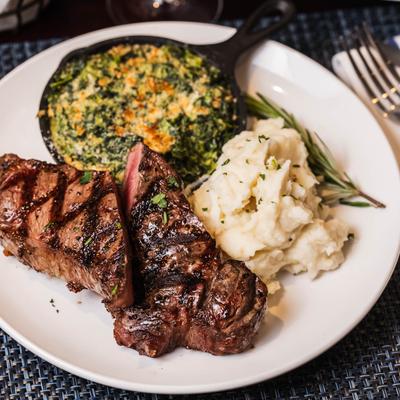 NY strip steak with a side of creamed spinach and mashed potatoes.