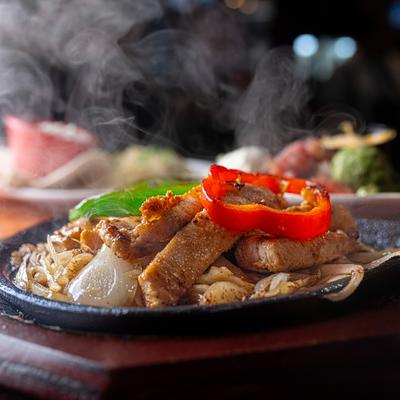 Chicken fajitas emitting steam, close up.