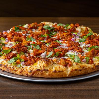 Malai pizza with chicken, red onions, tomatoes, green peppers and fresh cilantro.