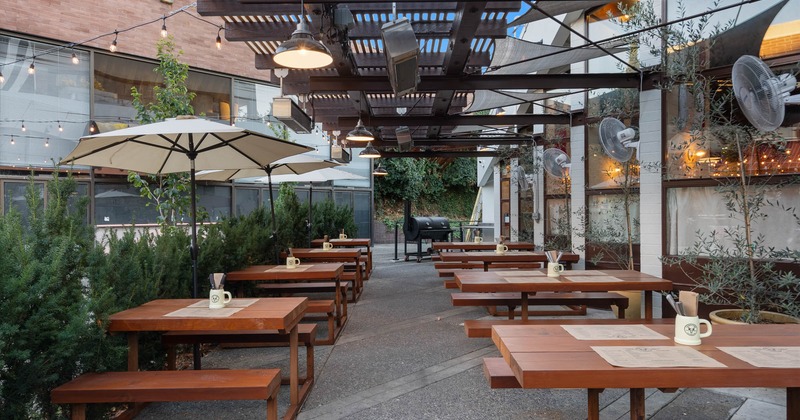 Exterior, covered seating area, wooden benches and tables, concrete flooring